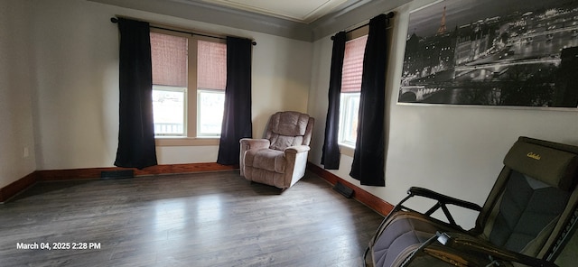 sitting room with crown molding, wood finished floors, visible vents, and baseboards