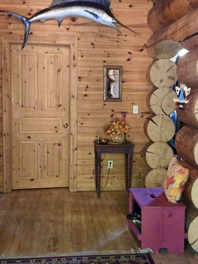 interior space with wood walls and dark wood-type flooring