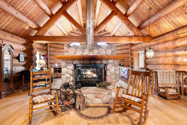 interior space featuring beam ceiling, a fireplace, and log walls