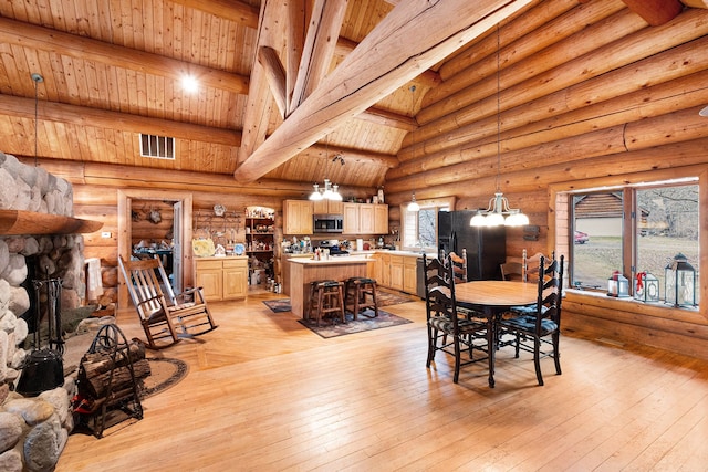 dining room with beam ceiling, rustic walls, wood ceiling, and light wood-type flooring