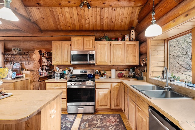 kitchen featuring appliances with stainless steel finishes, hanging light fixtures, light brown cabinetry, and sink