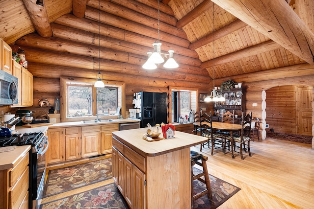 kitchen featuring light brown cabinets, a center island, stainless steel appliances, and rustic walls