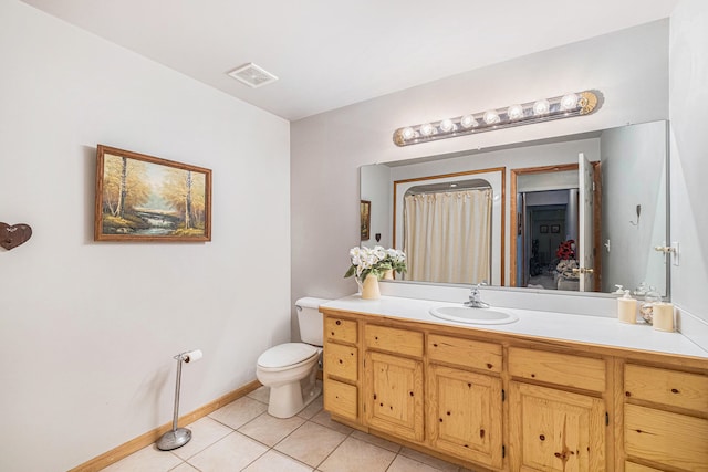 bathroom featuring tile patterned flooring, vanity, and toilet