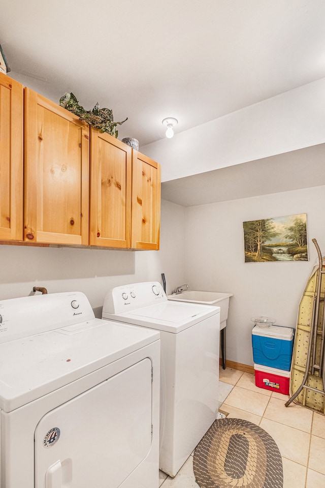 washroom with cabinets, independent washer and dryer, light tile patterned floors, and sink