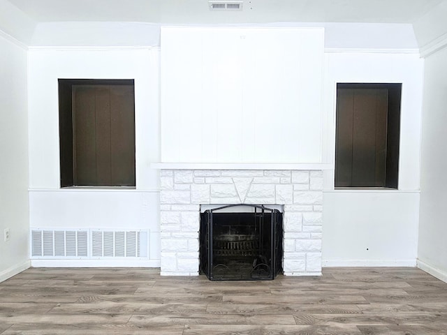 room details featuring hardwood / wood-style floors, crown molding, and a fireplace