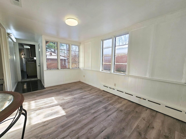 unfurnished sunroom featuring a baseboard radiator