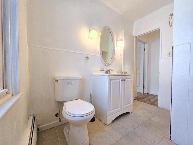 bathroom featuring tile patterned flooring, vanity, toilet, and baseboard heating