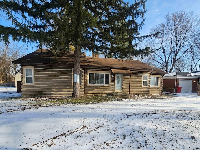 cabin with a garage and an outbuilding