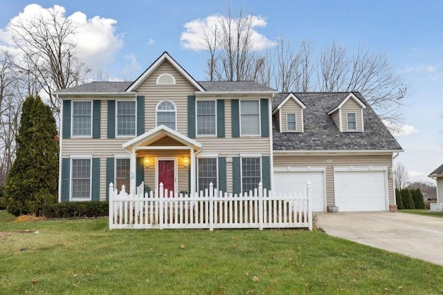 colonial-style house featuring a front yard, fence, driveway, and an attached garage