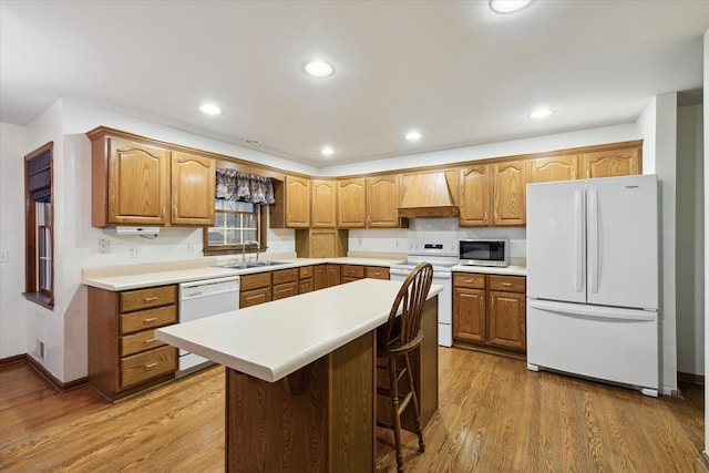 kitchen featuring custom exhaust hood, a breakfast bar, white appliances, sink, and wood-type flooring