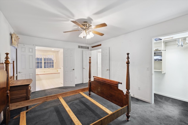 carpeted bedroom with a walk in closet, connected bathroom, ceiling fan, and a closet