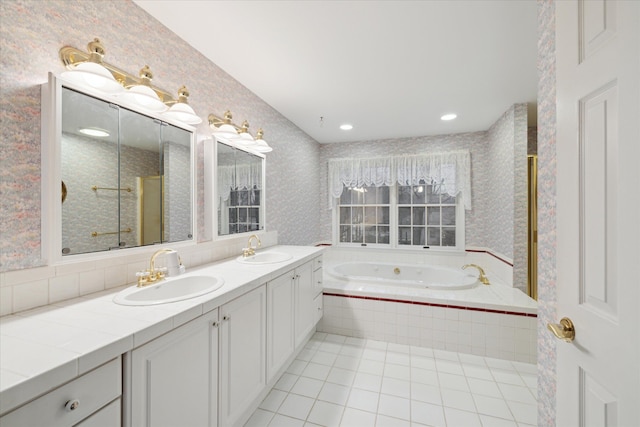 bathroom with vanity, tiled tub, and tile patterned floors