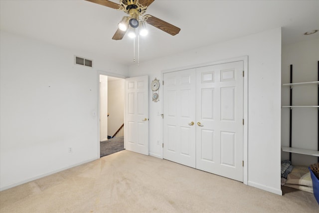 unfurnished bedroom with light colored carpet, a closet, and ceiling fan