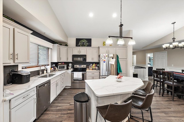 kitchen featuring lofted ceiling, hanging light fixtures, and appliances with stainless steel finishes