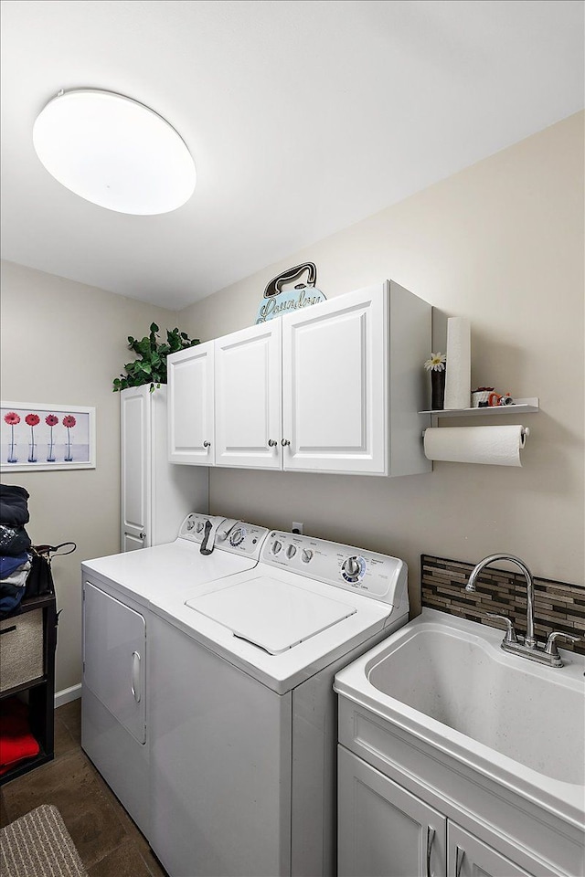 clothes washing area with cabinets, sink, and washer and dryer