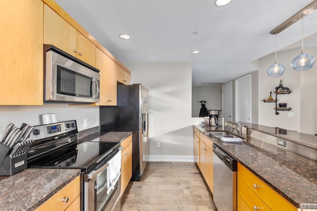 335 Bridge St NW Unit 2602, Grand Rapids, MI 49504 - kitchen featuring stainless steel appliances, light wood-style floors, a peninsula, light brown cabinetry, and dark stone counters