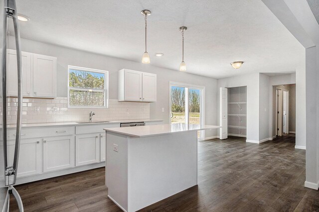 7942 Sierra Dr, Belding, MI 48809 - kitchen featuring white cabinetry, a sink, light countertops, baseboards, and backsplash