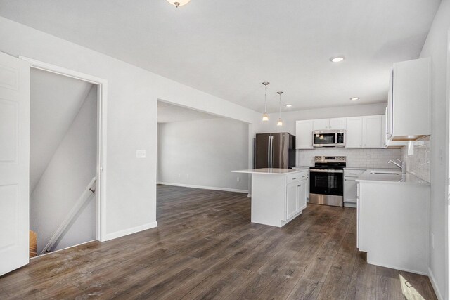 7942 Sierra Dr, Belding, MI 48809 - kitchen featuring decorative backsplash, appliances with stainless steel finishes, a sink, white cabinetry, and a center island