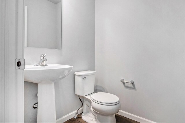 7942 Sierra Dr, Belding, MI 48809 - bathroom featuring wood finished floors, toilet, and baseboards