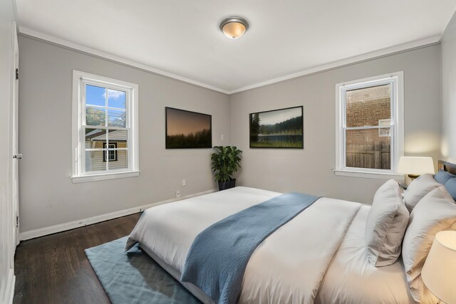 bedroom with ornamental molding and dark wood-type flooring