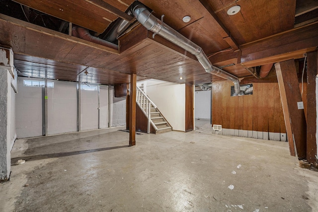 basement featuring wood walls