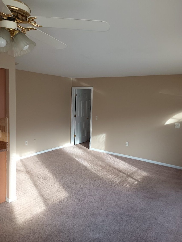 carpeted spare room with ceiling fan and vaulted ceiling