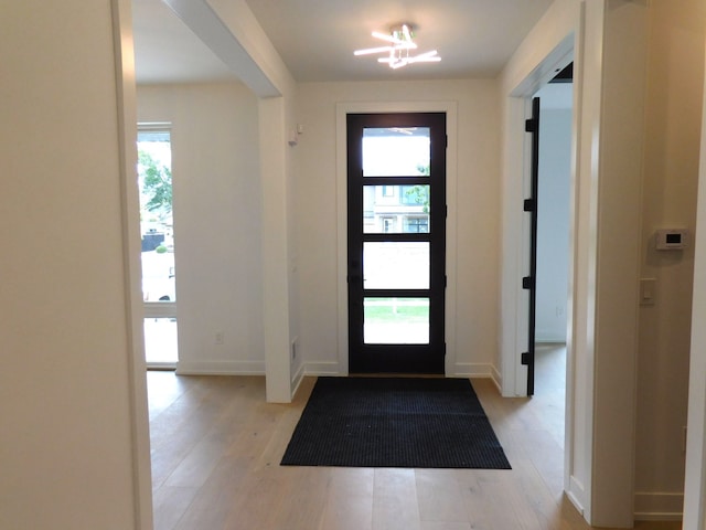 foyer entrance featuring light hardwood / wood-style flooring and a notable chandelier