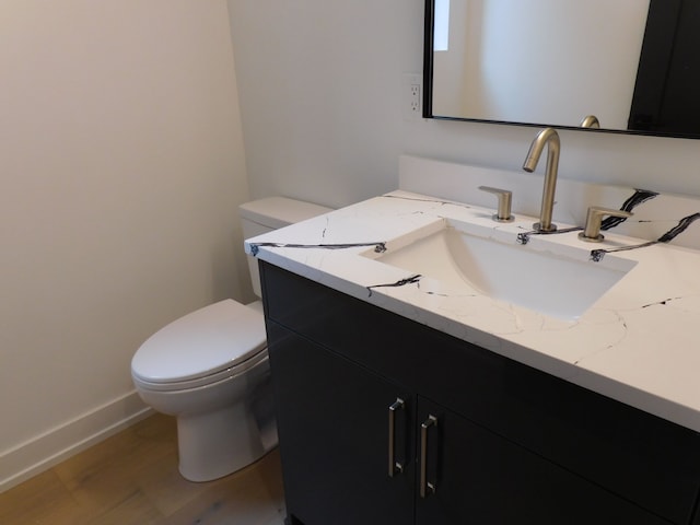 bathroom featuring vanity, hardwood / wood-style flooring, and toilet