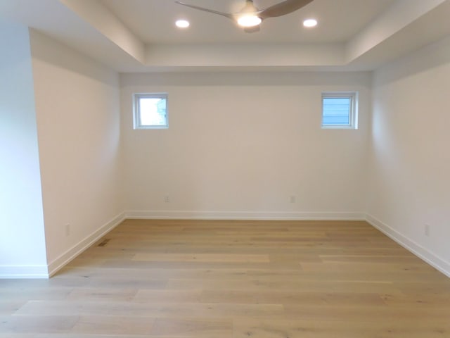 basement featuring ceiling fan and light hardwood / wood-style floors