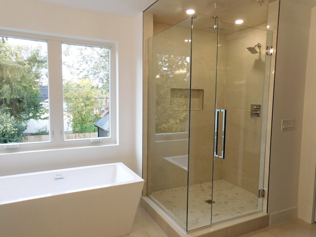 bathroom with tile patterned flooring, a healthy amount of sunlight, and independent shower and bath