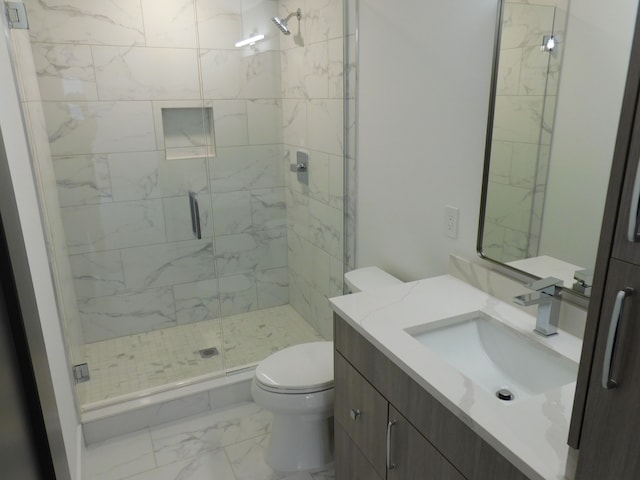 bathroom featuring an enclosed shower, vanity, and toilet