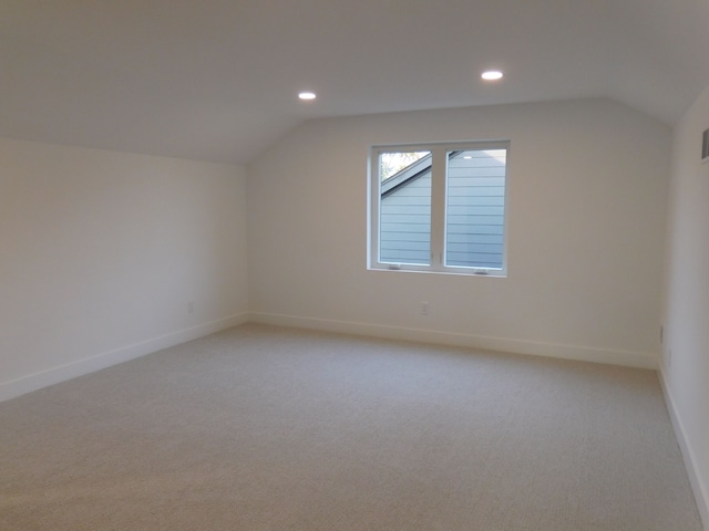 bonus room featuring light carpet and vaulted ceiling