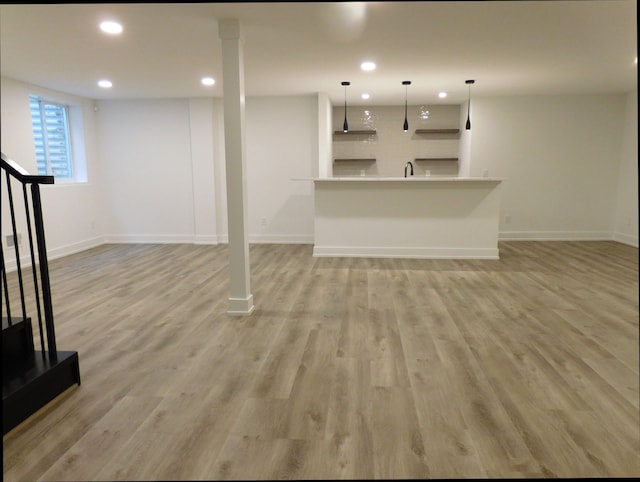 basement with light hardwood / wood-style flooring