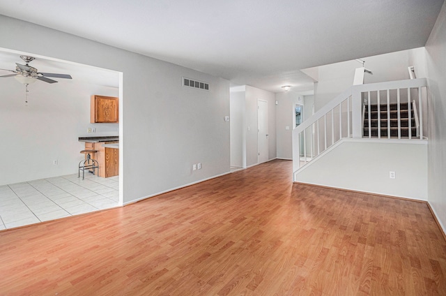 unfurnished living room with ceiling fan and light hardwood / wood-style flooring