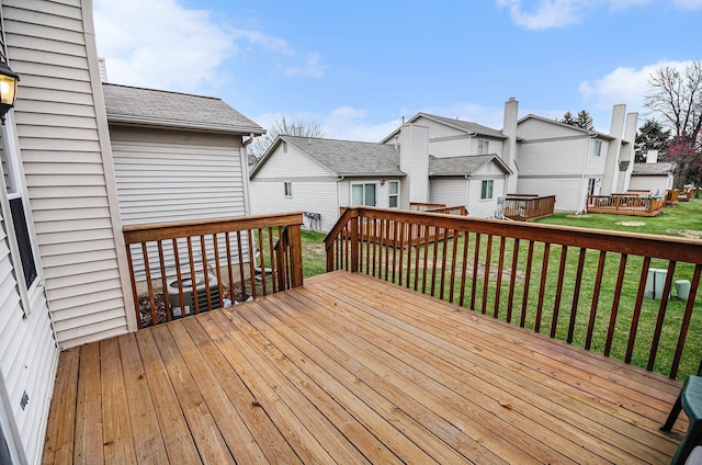 wooden terrace featuring a lawn