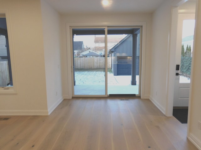 entryway with visible vents, baseboards, and wood finished floors