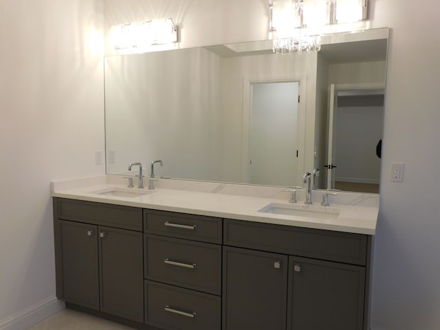 full bath featuring a sink, baseboards, and double vanity