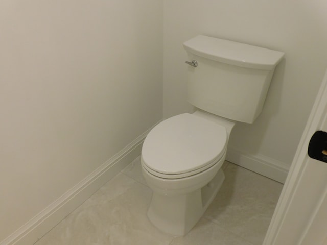 bathroom with toilet, tile patterned flooring, and baseboards