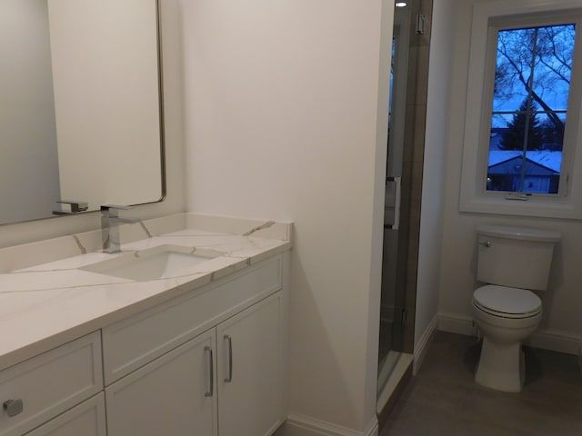 bathroom featuring toilet, a shower stall, vanity, and baseboards