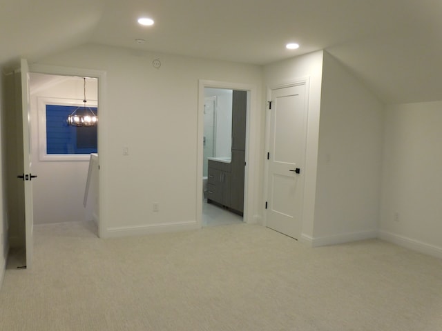 unfurnished bedroom with a chandelier, recessed lighting, light carpet, baseboards, and vaulted ceiling