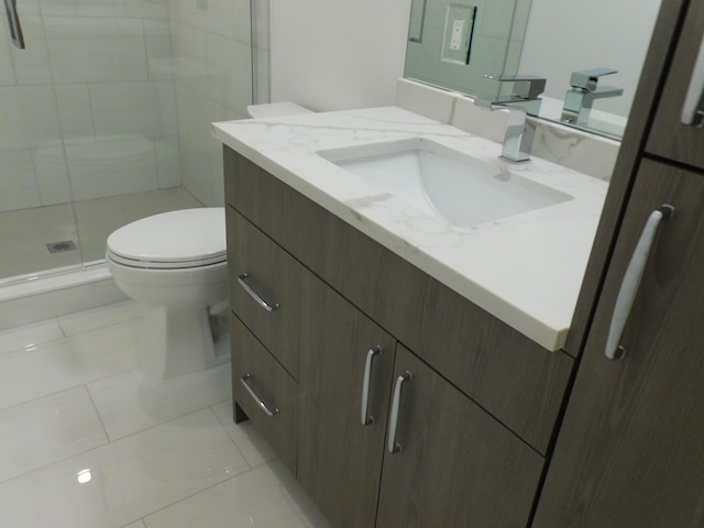 bathroom with vanity, a shower stall, toilet, and tile patterned floors