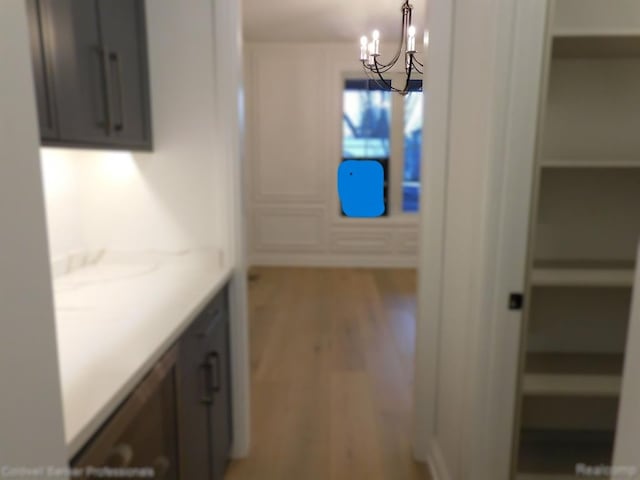 hallway featuring a chandelier and wood finished floors