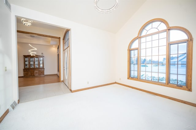 tiled empty room with plenty of natural light and lofted ceiling