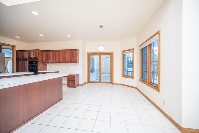 kitchen featuring stainless steel fridge, decorative light fixtures, and black oven