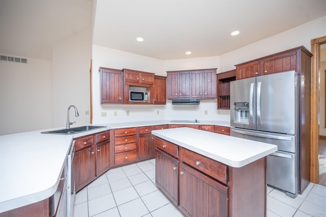 kitchen with a center island, sink, kitchen peninsula, light tile patterned floors, and appliances with stainless steel finishes