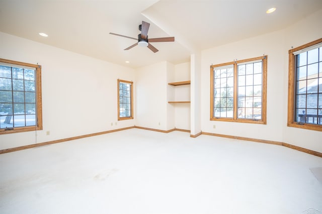 unfurnished living room with ceiling fan and built in features