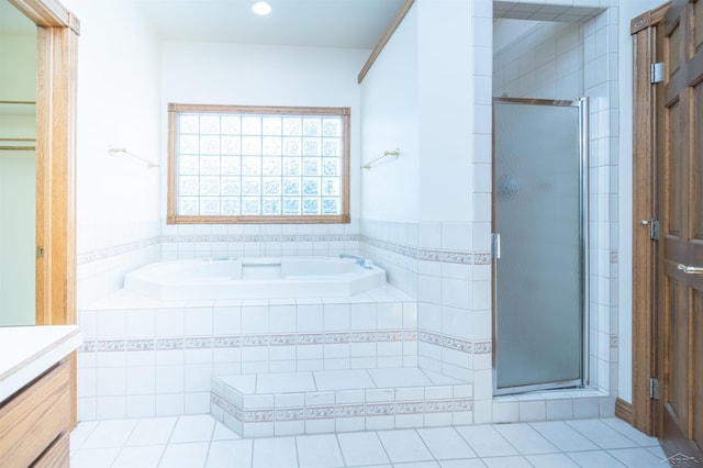 bathroom featuring tile patterned floors, vanity, and shower with separate bathtub