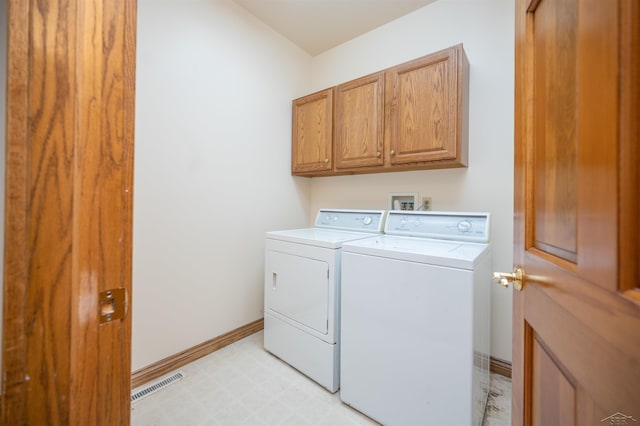 washroom featuring cabinets and washing machine and clothes dryer