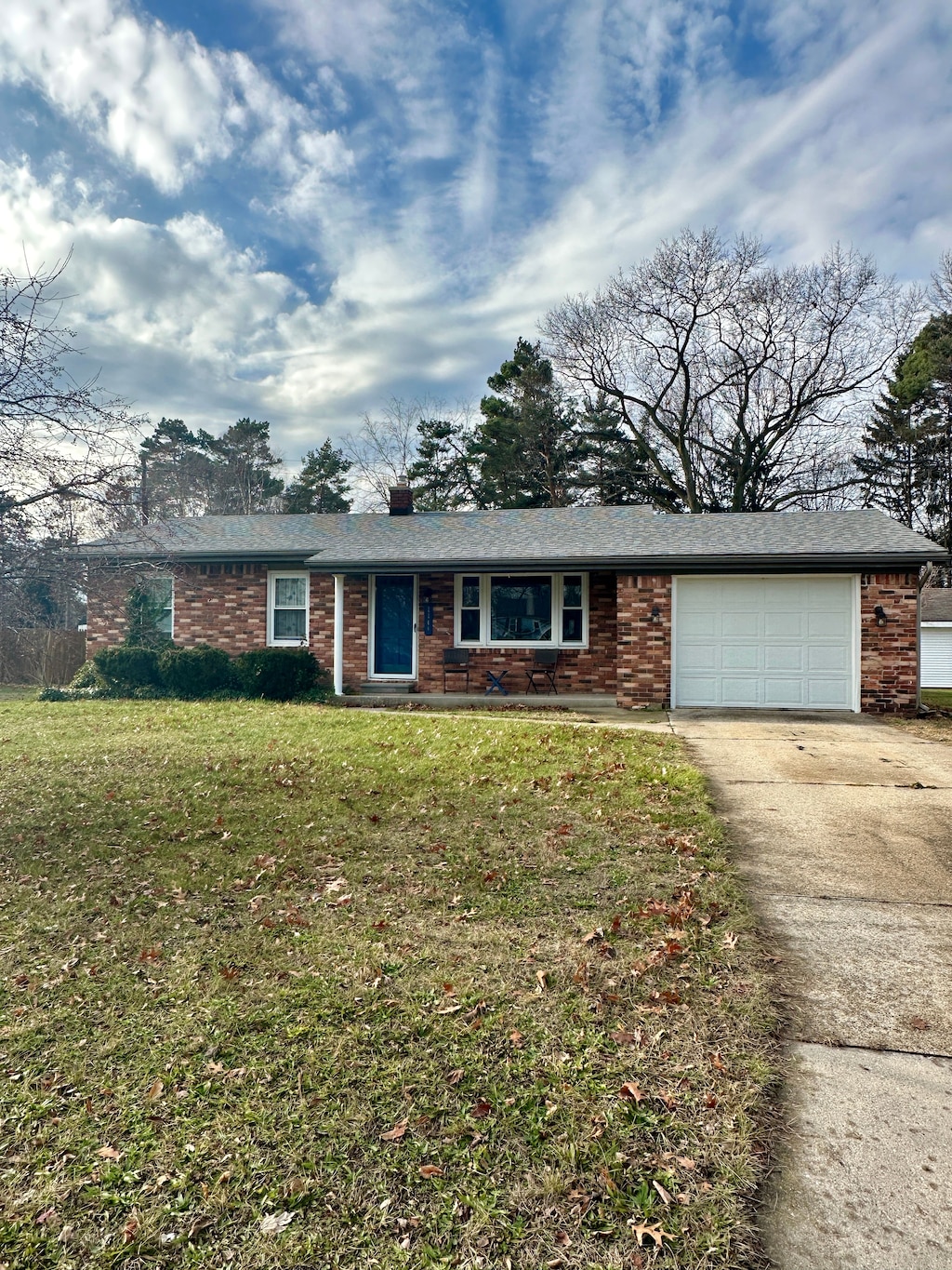 ranch-style house with a garage and a front lawn