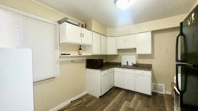 kitchen featuring white cabinets, dark hardwood / wood-style flooring, sink, and black appliances